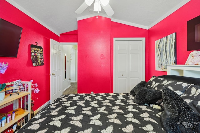 carpeted bedroom with a closet, vaulted ceiling, ceiling fan, and ornamental molding