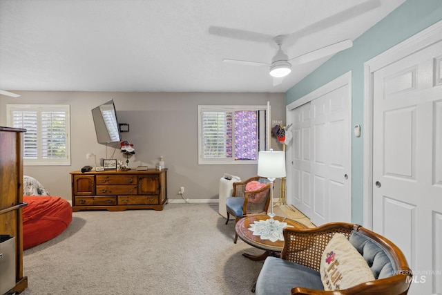 sitting room featuring ceiling fan, carpet floors, and a wealth of natural light