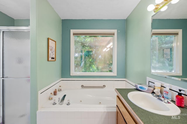 bathroom featuring vanity, a healthy amount of sunlight, and separate shower and tub