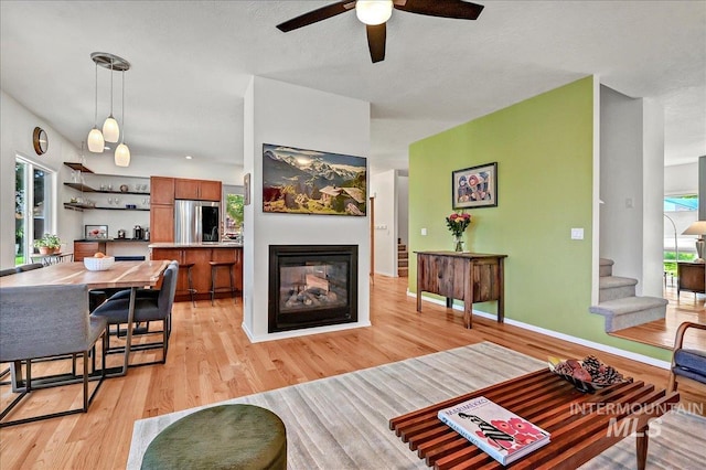 2942 E Eastgate Dr, Boise, ID 83716 - living room featuring light wood finished floors, a multi sided fireplace, a ceiling fan, and stairway