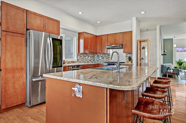 2942 E Eastgate Dr, Boise, ID 83716 - kitchen featuring smart refrigerator, light wood-style floors, under cabinet range hood, decorative backsplash, and light stone countertops