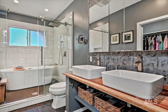 2942 E Eastgate Dr, Boise, ID 83716 - bathroom with a shower stall, toilet, wood finished floors, double vanity, and tile walls