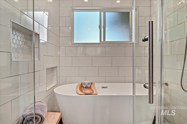 2942 E Eastgate Dr, Boise, ID 83716 - bathroom with tile walls, a freestanding bath, and a stall shower