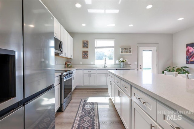 837 Trout Creek Way, Kimberly, ID 83314 - kitchen with appliances with stainless steel finishes, light wood-style floors, white cabinets, recessed lighting, and light stone counters