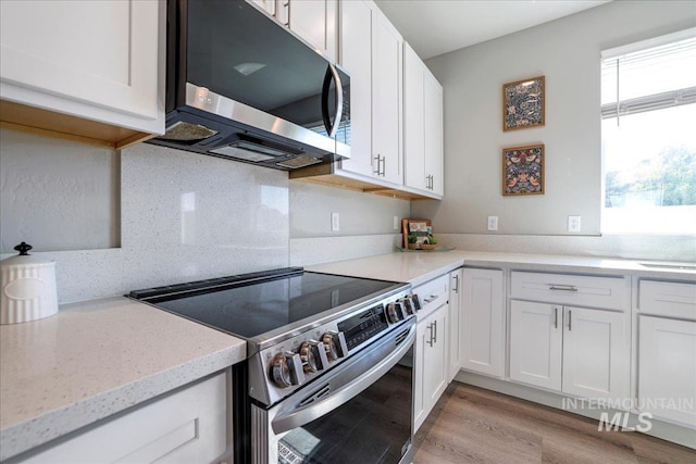 837 Trout Creek Way, Kimberly, ID 83314 - kitchen with appliances with stainless steel finishes, white cabinets, decorative backsplash, light wood-style floors, and light stone counters