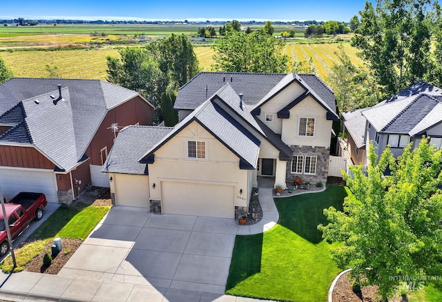 3031 N Christian Way, Meridian, ID 83646 - view of front of house with stone siding, stucco siding, driveway, and a view of countryside