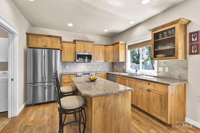 3031 N Christian Way, Meridian, ID 83646 - kitchen featuring appliances with stainless steel finishes, light stone countertops, a kitchen island, washer / dryer, and recessed lighting
