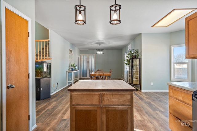 kitchen with pendant lighting, dark hardwood / wood-style floors, and a kitchen island