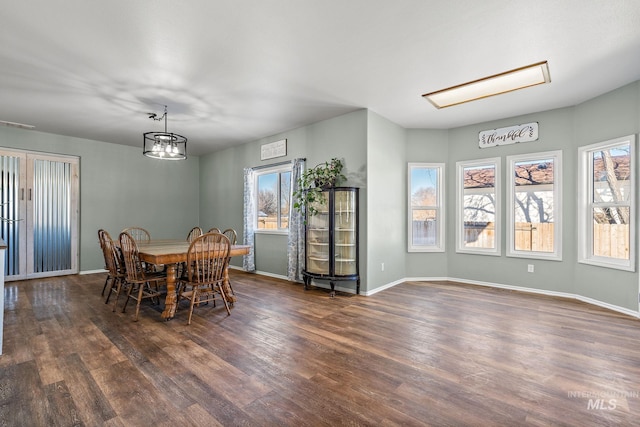 dining room with a notable chandelier and dark wood-type flooring