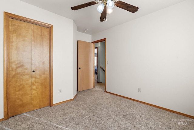 unfurnished bedroom with ceiling fan, a closet, and carpet