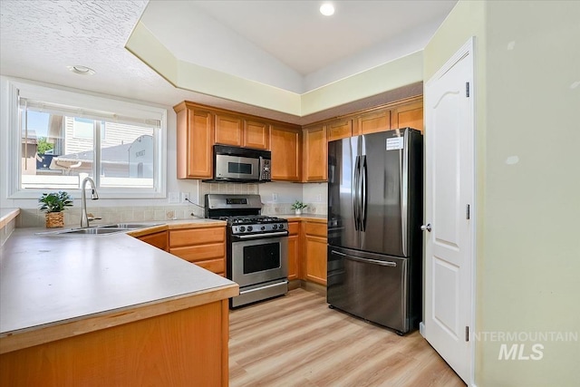 2888 W Wilder St, Meridian, ID 83642 - kitchen with freestanding refrigerator, stainless steel gas stove, light wood finished floors, light countertops, and brown cabinets