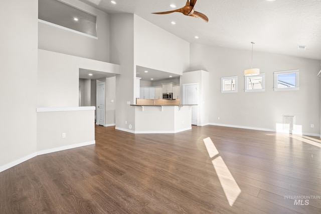 unfurnished living room with ceiling fan, dark hardwood / wood-style flooring, and high vaulted ceiling