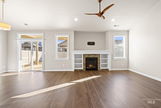 unfurnished living room featuring dark hardwood / wood-style flooring, a textured ceiling, and ceiling fan