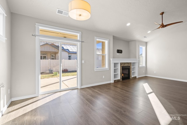 unfurnished living room featuring dark hardwood / wood-style floors and a tile fireplace