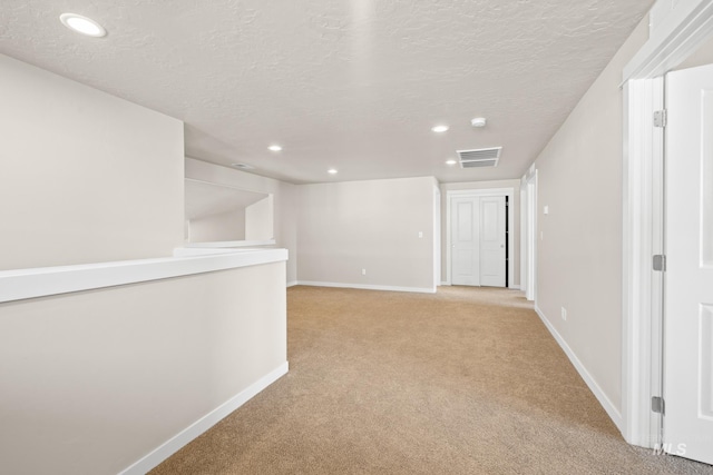 interior space featuring light carpet and a textured ceiling