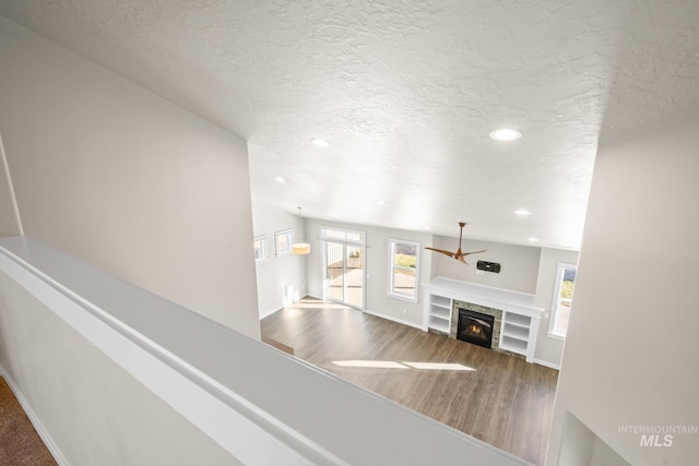 unfurnished living room with wood-type flooring and a textured ceiling