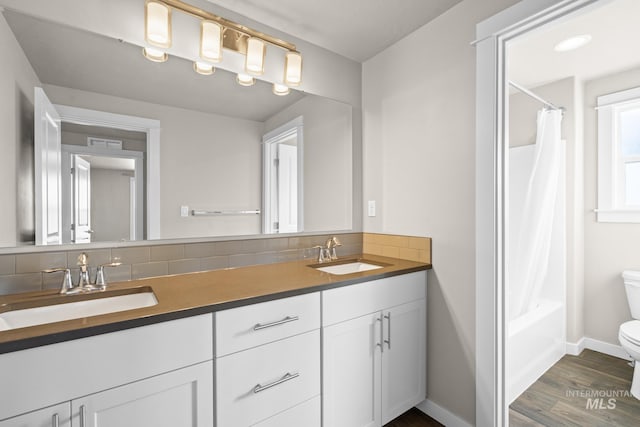 full bathroom with vanity, hardwood / wood-style flooring, toilet, and shower / bath combo with shower curtain