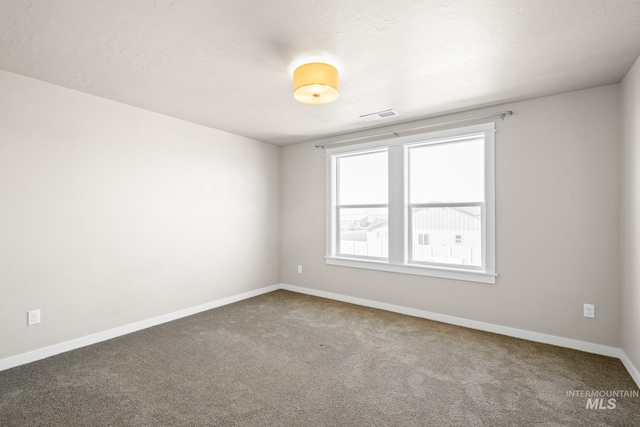 unfurnished room featuring carpet and a textured ceiling