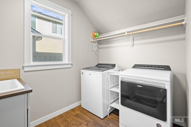 clothes washing area featuring dark hardwood / wood-style flooring, separate washer and dryer, and sink