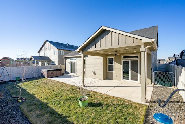 rear view of house featuring a yard, a patio area, a hot tub, and ceiling fan