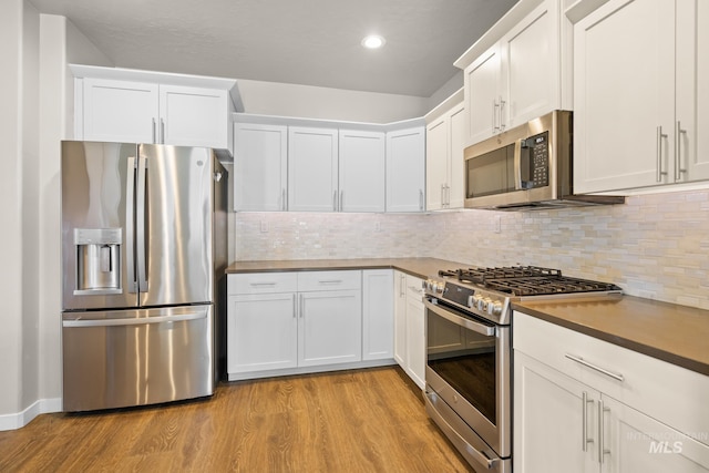 kitchen featuring white cabinetry, tasteful backsplash, stainless steel appliances, and light hardwood / wood-style floors