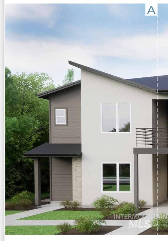 view of front of house featuring stucco siding and a balcony