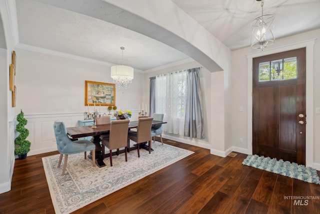12371 S Abbott Downing Way, Nampa, ID 83686 - interior space with an inviting chandelier, crown molding, baseboards, dark wood-type flooring, and arched walkways