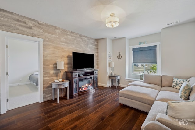 12371 S Abbott Downing Way, Nampa, ID 83686 - living room featuring visible vents, wood finished floors, a glass covered fireplace, wooden walls, and an accent wall