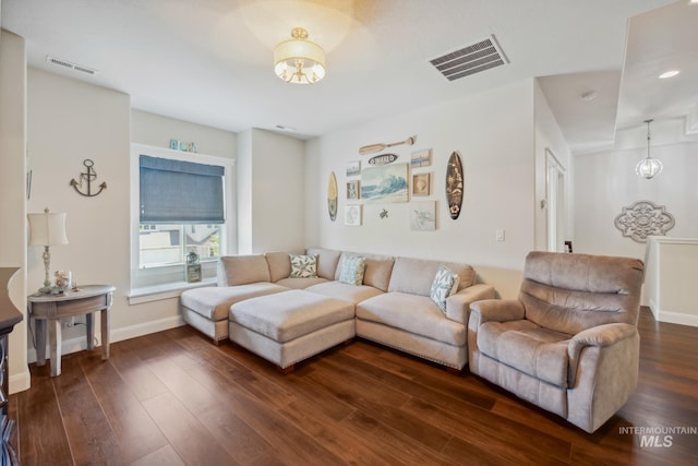 12371 S Abbott Downing Way, Nampa, ID 83686 - living room featuring dark wood-style flooring, baseboards, visible vents, and a notable chandelier