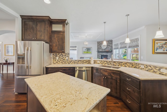 12371 S Abbott Downing Way, Nampa, ID 83686 - kitchen featuring dark brown cabinets, appliances with stainless steel finishes, a sink, a fireplace, and tasteful backsplash