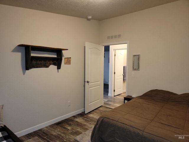 bedroom with wood-type flooring and a textured ceiling