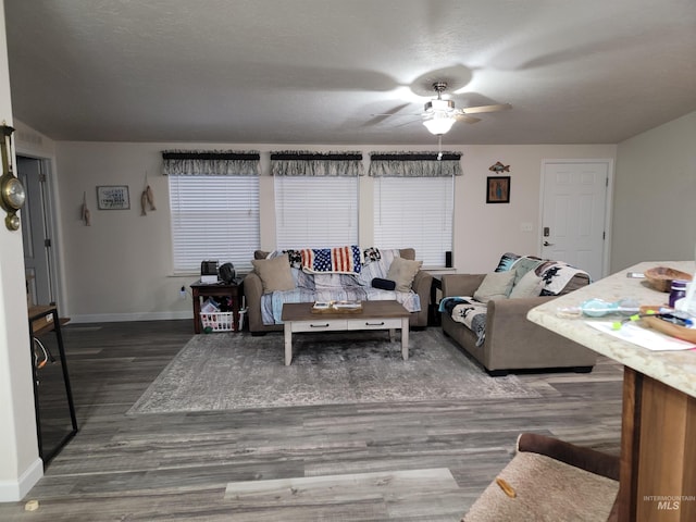 living room with ceiling fan and dark wood-type flooring