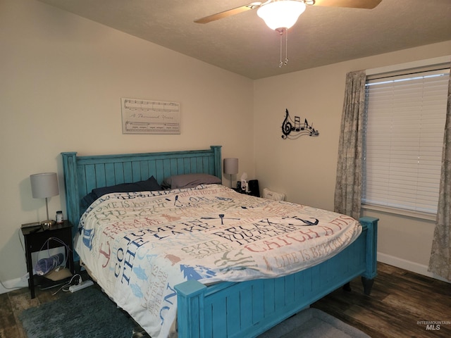 bedroom with a textured ceiling, ceiling fan, and dark wood-type flooring