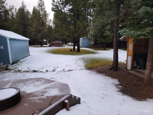 yard layered in snow with a storage shed