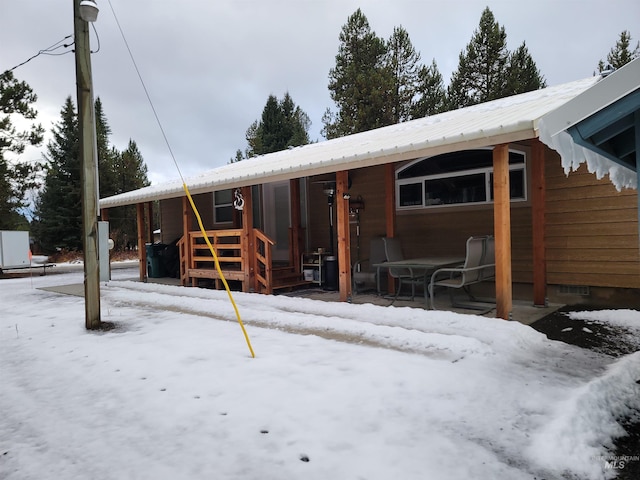 view of snow covered rear of property