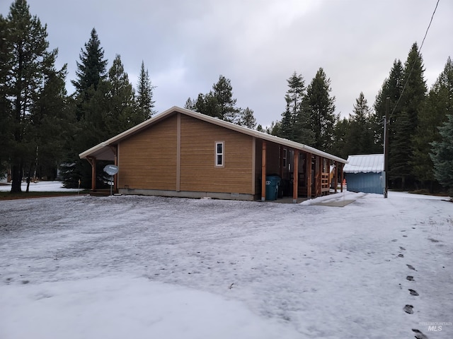 view of snowy exterior featuring an outdoor structure