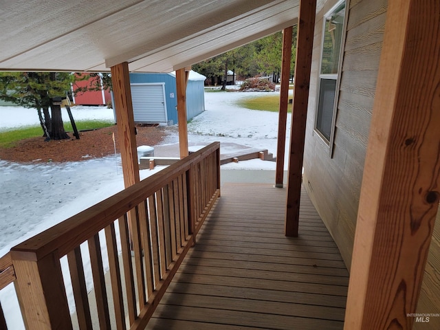 snow covered deck with a storage shed