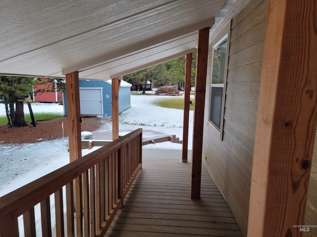 snow covered deck with a shed