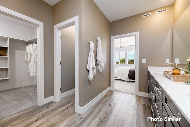 bathroom with hardwood / wood-style flooring, vanity, and a chandelier