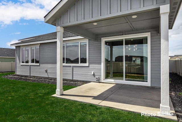 entrance to property featuring a lawn and a patio