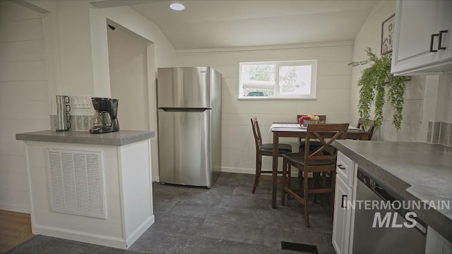 kitchen with white cabinets and stainless steel fridge