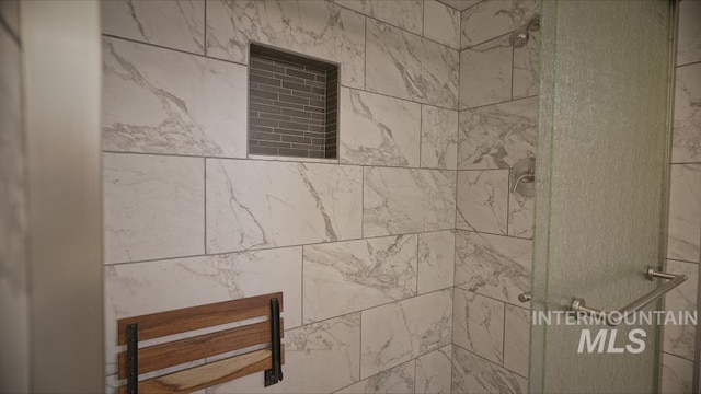 interior details featuring a tile shower