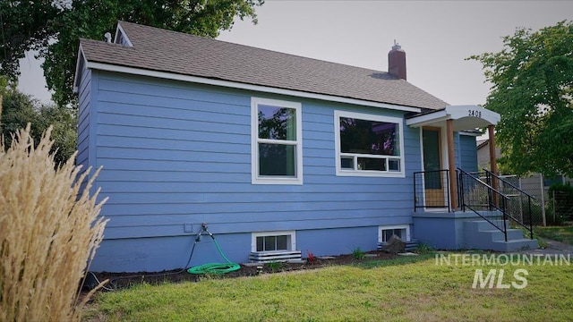 view of side of property with a lawn