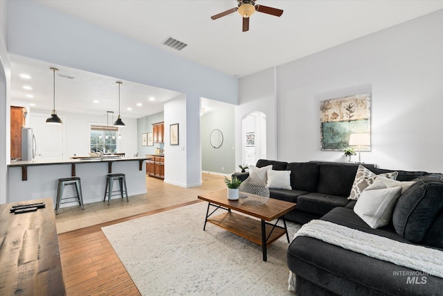 living room with light hardwood / wood-style flooring and ceiling fan