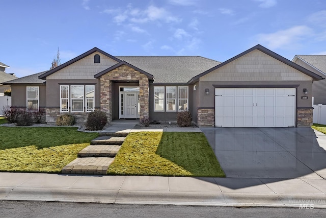 craftsman-style home with an attached garage, stone siding, concrete driveway, stucco siding, and a front lawn