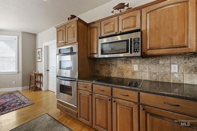 kitchen with stainless steel appliances, decorative backsplash, and brown cabinets