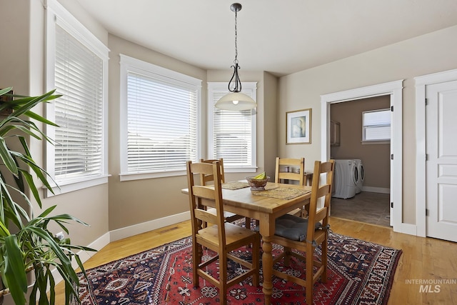 dining room with light wood-type flooring, plenty of natural light, and washer and clothes dryer