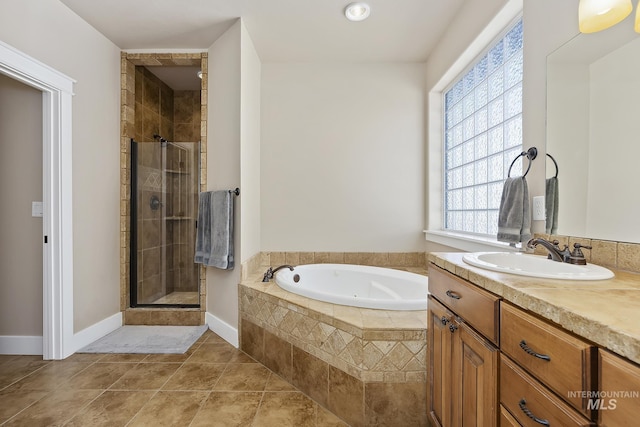 full bath with a shower stall, vanity, tile patterned flooring, baseboards, and a bath