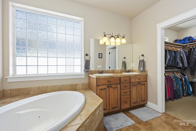 full bathroom featuring a walk in closet, a sink, a jetted tub, and double vanity