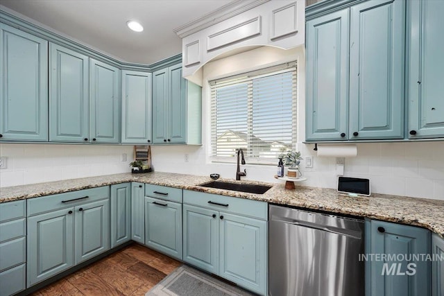 kitchen featuring decorative backsplash, dishwasher, blue cabinetry, and a sink